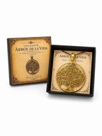 Colgante dorado Árbol de la Vida presentado en su estuche negro junto a la tapa ilustrada de Misticarium.