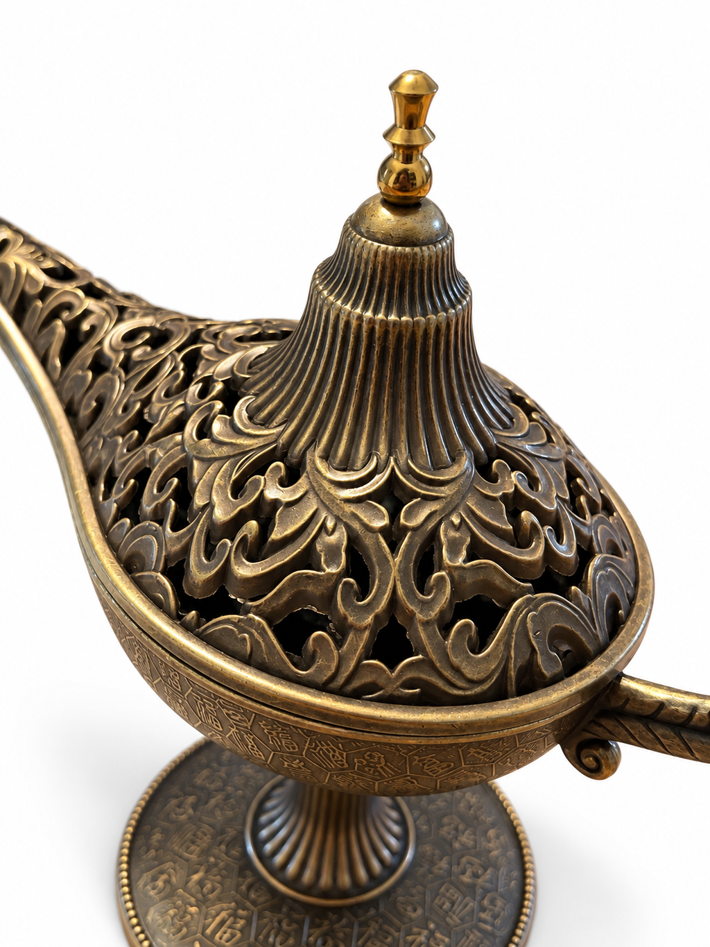 Primer plano de la tapa calada y ornamentada de una lámpara mágica decorativa con acabado envejecido en bronce.