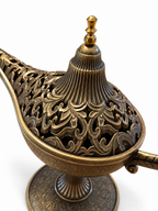 Primer plano de la tapa calada y ornamentada de una lámpara mágica decorativa con acabado envejecido en bronce.