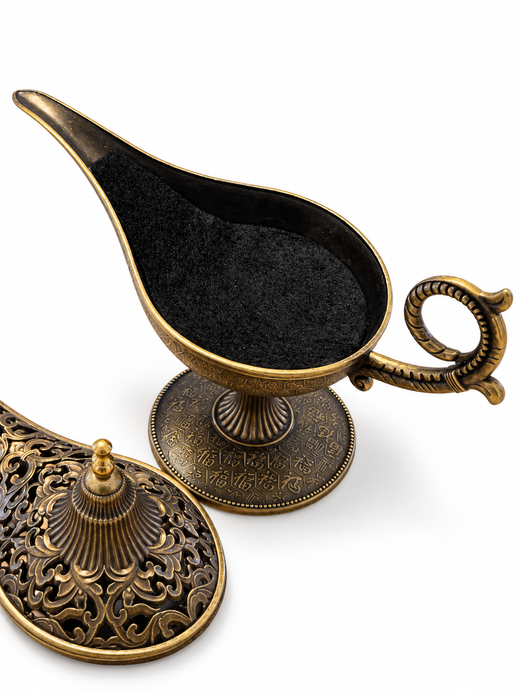 Lámpara mágica de estilo oriental en acabado bronce, abierta y con la tapa decorativa colocada al lado sobre fondo blanco.